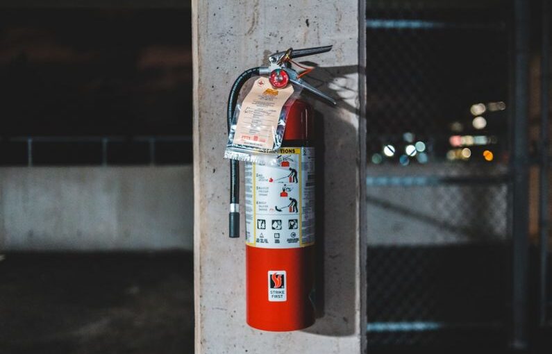 Fire Safety - red fire extinguisher mounted on wall