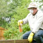 Organic Fertilizer - man in white long sleeve shirt and blue denim jeans sitting on brown wooden fence during