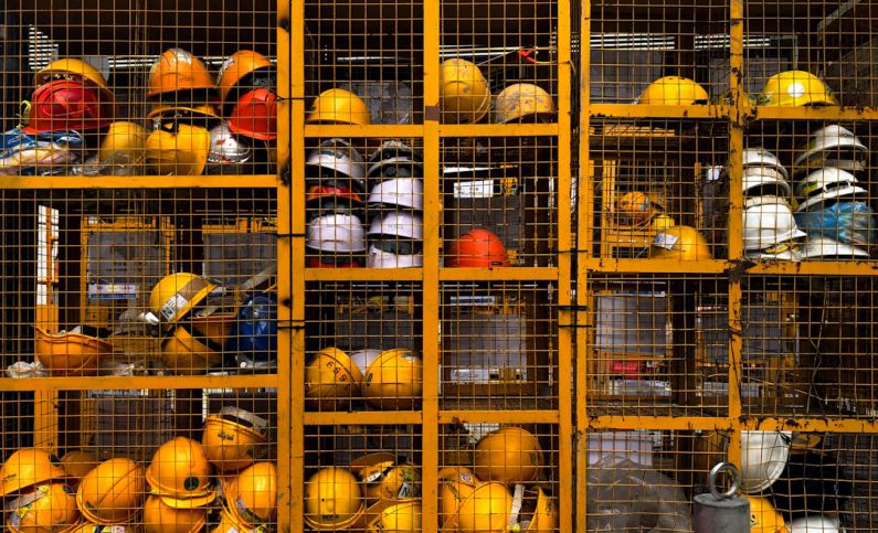 Safety Equipment - a rack filled with lots of yellow hard hats