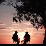 Mature Tree - silhouette of two person sitting on chair near tree
