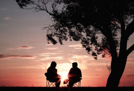 Mature Tree - silhouette of two person sitting on chair near tree