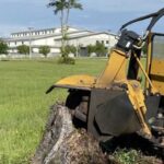 Stump Grinding - a tractor that is sitting in the grass
