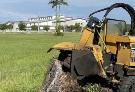 Stump Grinding - a tractor that is sitting in the grass