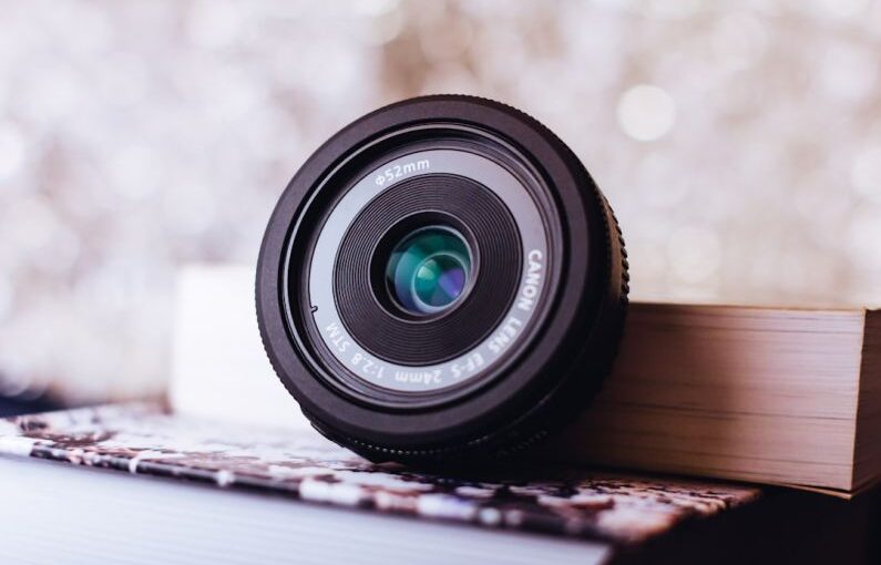 Mulching Technique - black Canon camera lens leaning on white book