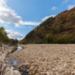 Drought Impact - a river running through a lush green hillside